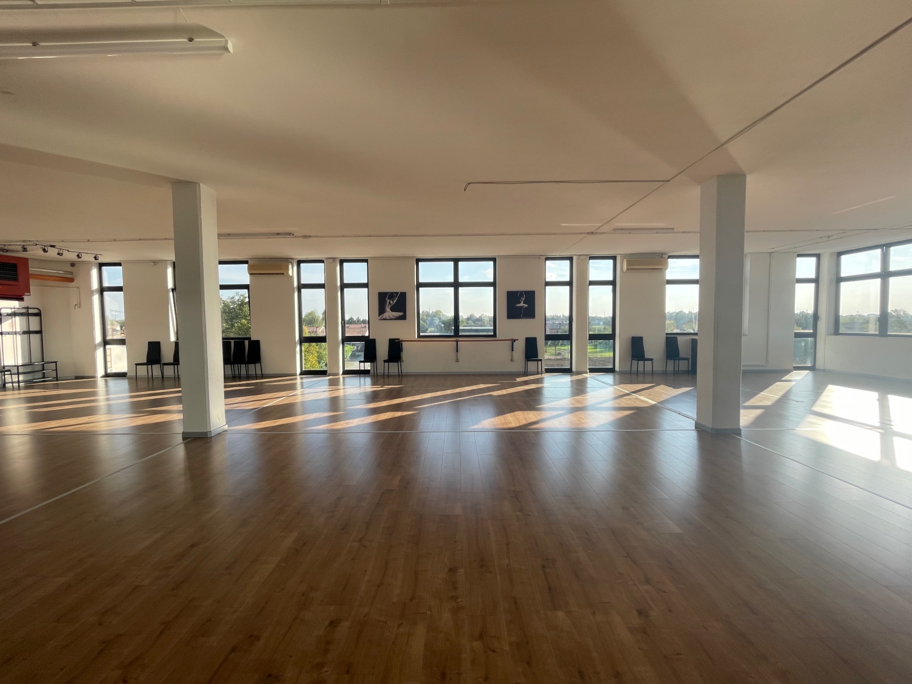 Sala White, ampio spazio con pavimento in laminato effetto legno, colonne e finestre