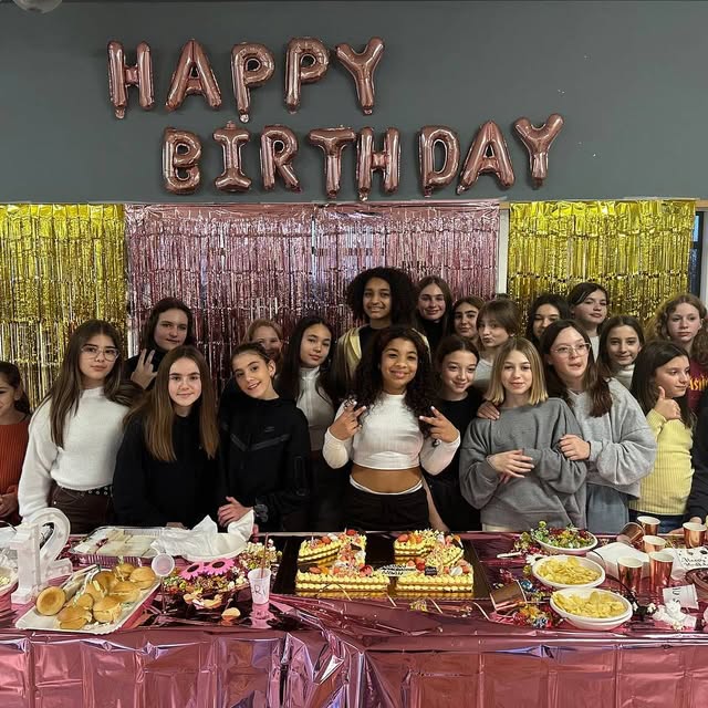Gruppo di ragazzi davanti alla parete Happy Birthday